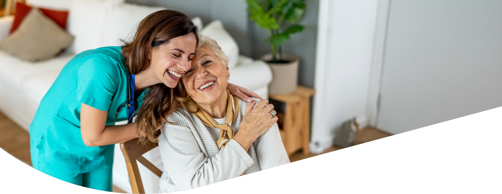 Pflegerin und Seniorin lachen gemeinsam